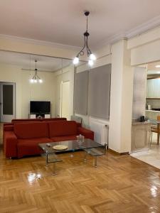 ein Wohnzimmer mit einem roten Sofa und einem Tisch in der Unterkunft Elegant Apartment in Athen