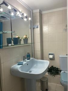ein Badezimmer mit einem Waschbecken, einem Spiegel und einem WC in der Unterkunft Elegant Apartment in Athen