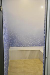 a bathroom with a shower with blue tiles at Ahsaray Hotel in Aksaray