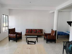 uma sala de estar com cadeiras de couro e um sofá em Casa Entre Los Arboles +Piscina em Nariño