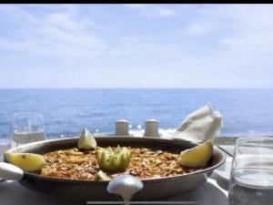 un plato de comida en una mesa con el océano en el fondo en MI CAPRICHO B12 - Beachfront Apartment- Costa del Sol, en Mijas Costa