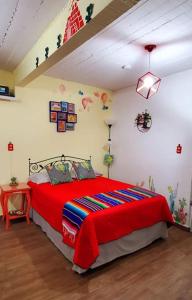 sypialnia z dużym łóżkiem i czerwonym kocem w obiekcie LA CASITA YALI w mieście San Martín de las Pirámides