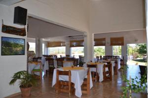 un restaurante con mesas y sillas blancas y ventanas en Hostal Solar de Piedras in 