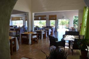 un comedor con mesas, sillas y ventanas en Hostal Solar de Piedras in 