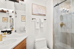 La salle de bains blanche est pourvue d'une douche et de toilettes. dans l'établissement Terracehouse by Snowmass Vacations, à Snowmass Village