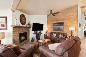 a living room with leather couches and a fireplace at Terracehouse by Snowmass Vacations in Snowmass Village