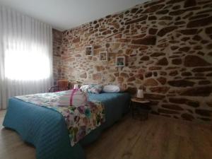 皮涅爾的住宿－Refúgio do Côa - Pure Countryside Experience，一间卧室设有石墙和一张床