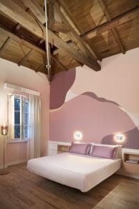 a bedroom with a large white bed with purple walls at Casa Clat in Cagliari