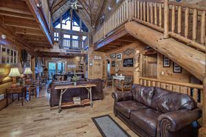 a living room with leather furniture in a log cabin at ERN854 - Wagon Wheel Lodge - Great Location! Close To All The Action! cabin in Pigeon Forge