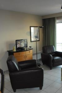 - un salon avec deux fauteuils en cuir et une lampe dans l'établissement Residence Scorpio, à Nieuport