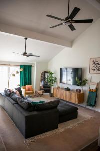 レックスバーグにあるFun 4 BR Rexburg Retreat and Game Room, Sleeps 12のリビングルーム(黒いソファ、薄型テレビ付)