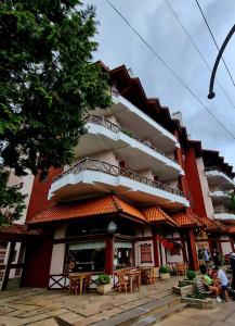 un edificio con tavoli e sedie di fronte ad esso di Apartamento Rua Torta a Gramado