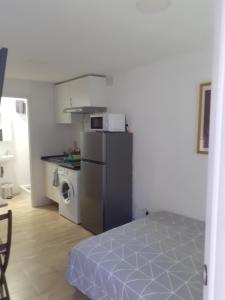 eine kleine Küche mit einem Kühlschrank und einer Mikrowelle in der Unterkunft Apartamento Estudio B-1 in Madrid