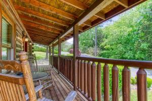 een veranda van een hut met uitzicht op het bos bij Little Slice of Heaven -1BR 1BA Close to Town and Resort Amenities cabin in Pigeon Forge