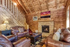 sala de estar con muebles de cuero y chimenea en ER1 - Smoky Mountain Escape Great location - Close to town! cabin, en Pigeon Forge