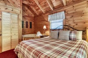 1 dormitorio con cama y bañera en una cabaña en ER1 - Smoky Mountain Escape Great location - Close to town! cabin, en Pigeon Forge