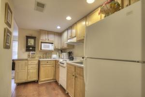 a kitchen with wooden cabinets and a white refrigerator at Colonial Crest 107 - Great location! - You can walk to town! condo in Pigeon Forge +6 photos