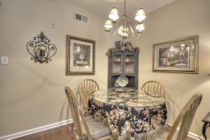 un comedor con una mesa con sillas y una lámpara de araña en Colonial Crest 107 - Great location! - You can walk to town! condo, en Pigeon Forge