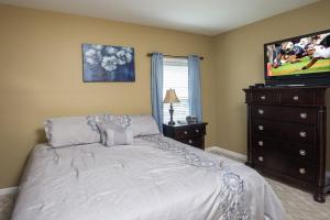 a bedroom with a bed and a flat screen tv at Colonial Crest 112 - Great location! - You can walk to town! condo in Pigeon Forge +10 photos