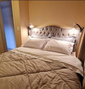 Una cama grande en un dormitorio con luces encendidas. en Apartamento Rua Torta, en Gramado