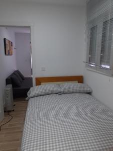 sypialnia z łóżkiem i kanapą w obiekcie Apartamento C w Madrycie