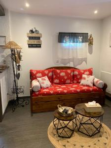 ein Wohnzimmer mit einem roten Sofa und einem Tisch in der Unterkunft Gîte de charme le val Mellis classé 3 étoiles dans la douceur provençale in Vaumeilh