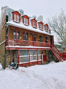 una casa de ladrillo con nieve encima en B&B Au Petit Roi, en Quebec