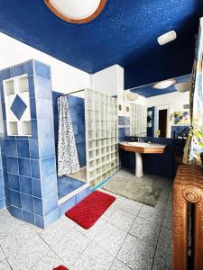 uma casa de banho com uma parede em azulejo azul e branco em B&B Au Petit Roi em Quebeque