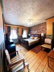 a bedroom with a bed and a couch and a chair at B&B Au Petit Roi in Quebec City