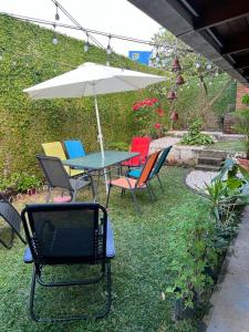 聖何塞的住宿－Corazón Sabana，院子里的桌椅和雨伞
