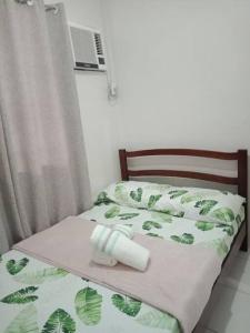 ein Bett mit einer Rolle Toilettenpapier darauf in der Unterkunft Cozy9-14 2BR at Mandaue City in Mandaue City