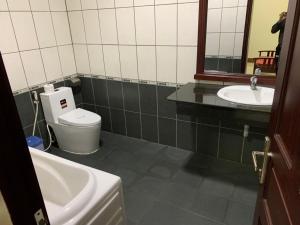 La salle de bains est pourvue d'un lavabo, de toilettes et d'un miroir. dans l'établissement Gold Rooster Resort, à Phan Rang