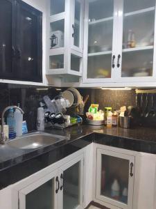 a kitchen with white cabinets and a sink at A sea view 3 bedroom beach vacation home in Camudmud