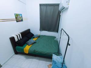 ein Schlafzimmer mit einem grünen Bett und einem Fenster in der Unterkunft Cozy 3 Bedroom Apartment Bandar Perda BM in Bukit Mertajam + 7 Fotos