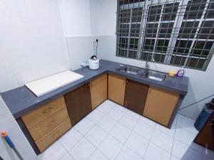 eine kleine Küche mit einem Waschbecken und einem Fenster in der Unterkunft Cozy 3 Bedroom Apartment Bandar Perda BM in Bukit Mertajam
