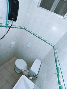 ein Badezimmer mit einer weißen Toilette und einem Waschbecken in der Unterkunft Cozy 3 Bedroom Apartment Bandar Perda BM in Bukit Mertajam