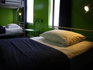 a bedroom with two beds and a green wall at Apple Hostels of Philadelphia in Philadelphia