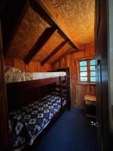 ネルトゥメにあるCabañas Llakolenのキャビン内の二段ベッド2台が備わる客室です。