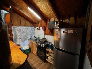 a kitchen with a refrigerator and a stove at Cabañas Llakolen in Neltume