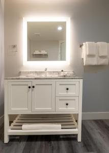 uma casa de banho com um lavatório branco e um espelho. em Onsen Hotel and Spa em Desert Hot Springs