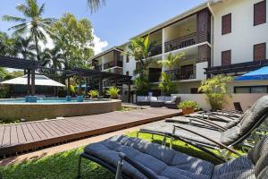 a group of lounge chairs in front of a building at Charming 1 bedroom Apt - Close to Town & Beach in Port Douglas