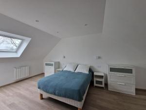 ein weißes Schlafzimmer mit einem Bett und einem Fenster in der Unterkunft Premium holiday home with living comfort at the highest level, Ploumilliau in Ploumilliau