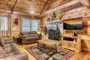 ein Wohnzimmer mit einem Kamin in einer Blockhütte in der Unterkunft HEAVENLY HEIGHTS - GREAT LOCATION! CLOSE TO ALL THE ACTION! cabin in Gatlinburg