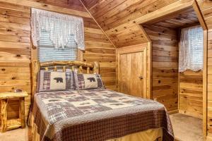 ein Schlafzimmer mit einem Bett in einem Blockhaus in der Unterkunft HEAVENLY HEIGHTS - GREAT LOCATION! CLOSE TO ALL THE ACTION! cabin in Gatlinburg
