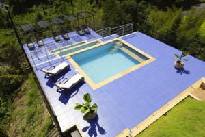 an overhead view of a swimming pool with two loungers and two chairs at shambhala ecohotel boutique la vega in La Vega +54 photos