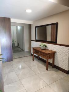 sala de estar con mesa y espejo en Apartamento Vivendas do Eucalipto, en Petrópolis