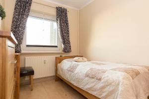 a bedroom with a bed and a window at Strandhochhaus 5 in Döse