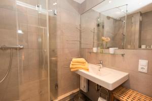 a bathroom with a sink and a shower and a mirror at Strandhochhaus 5 in Döse +8 photos