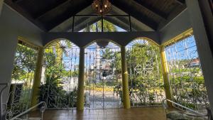 a room with a gate with windows and a chandelier at Yancey Largo Villa with Private Pool in Montego Bay