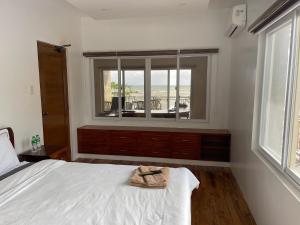 a bedroom with a bed and a window with a balcony at Nahas Beach Resort 
